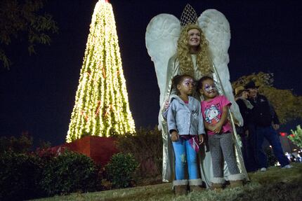 Jourdan Daily poses with 3 year-old twins Elsie Hibbard (left) and Rosena Hibbard at the...