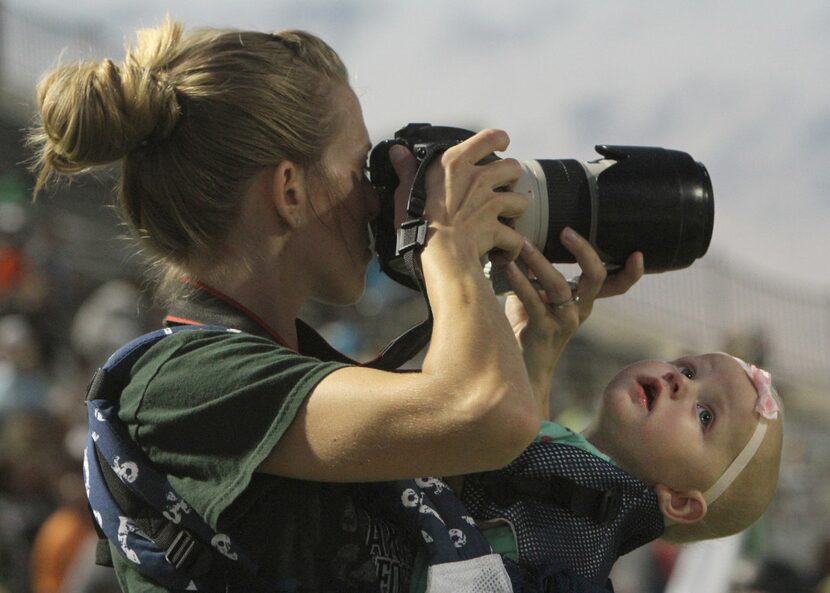 Fascinated by the moving images on the scoreboard's replay screen, 9-month old Addison...