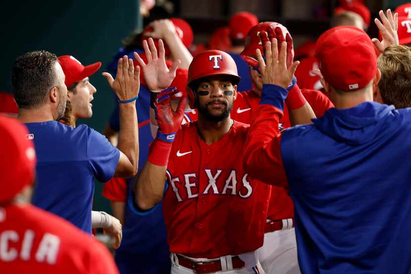 Texas Rangers center fielder Leody Taveras (3) high-fives teammates after hitting a home run...