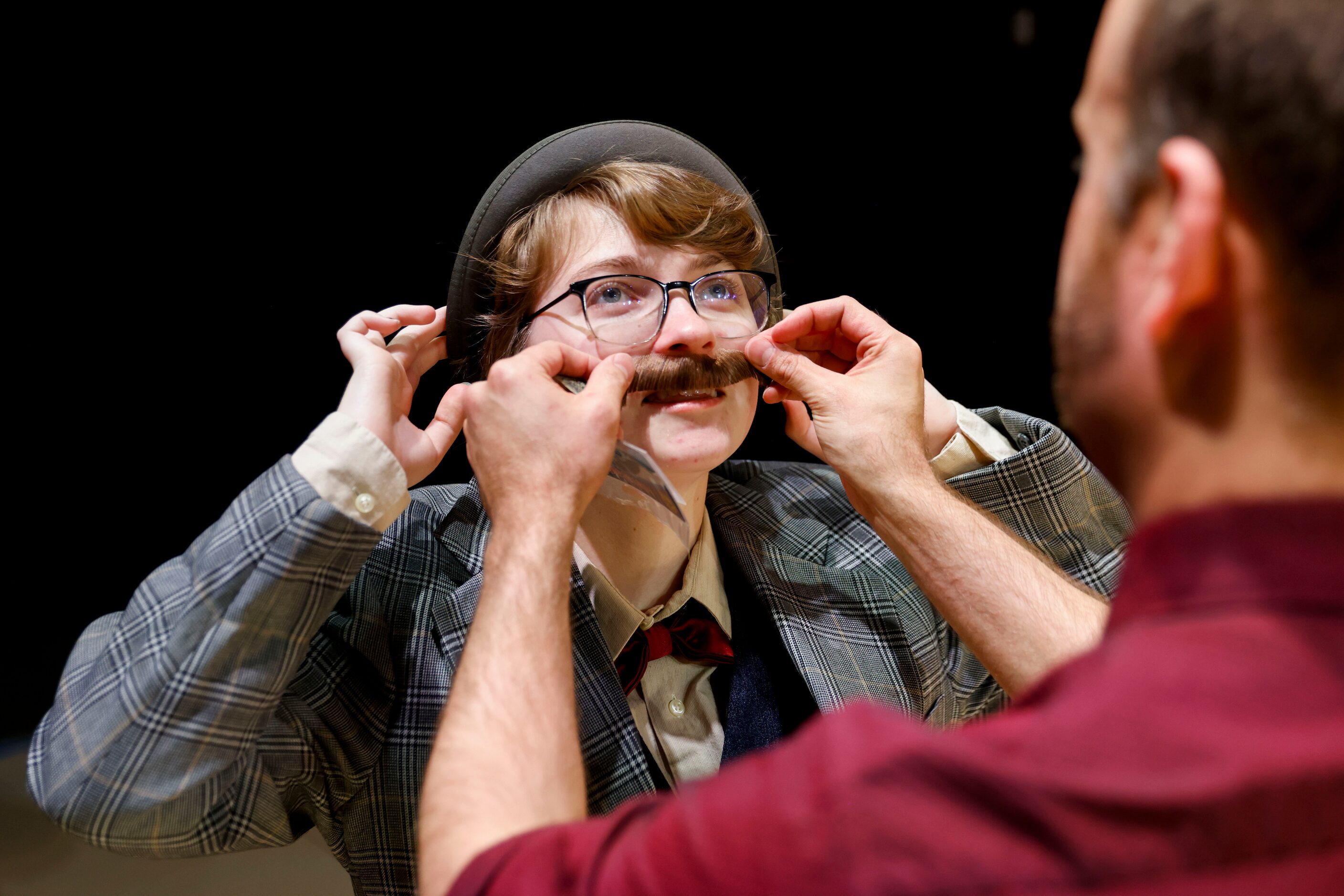 Theatre/artistic director Kyle Nichols tries out a prop mustache on Sherman High School...