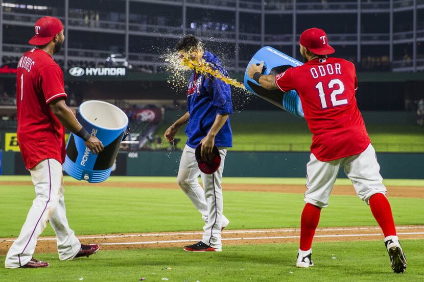Texas Rangers starting pitcher Martin Perez (33) is hit in the face with Gatorade by second...