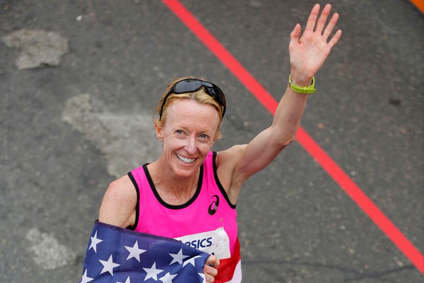 Former US Olympian Deena Kastor  greets her fans after finishing in third place with a time...
