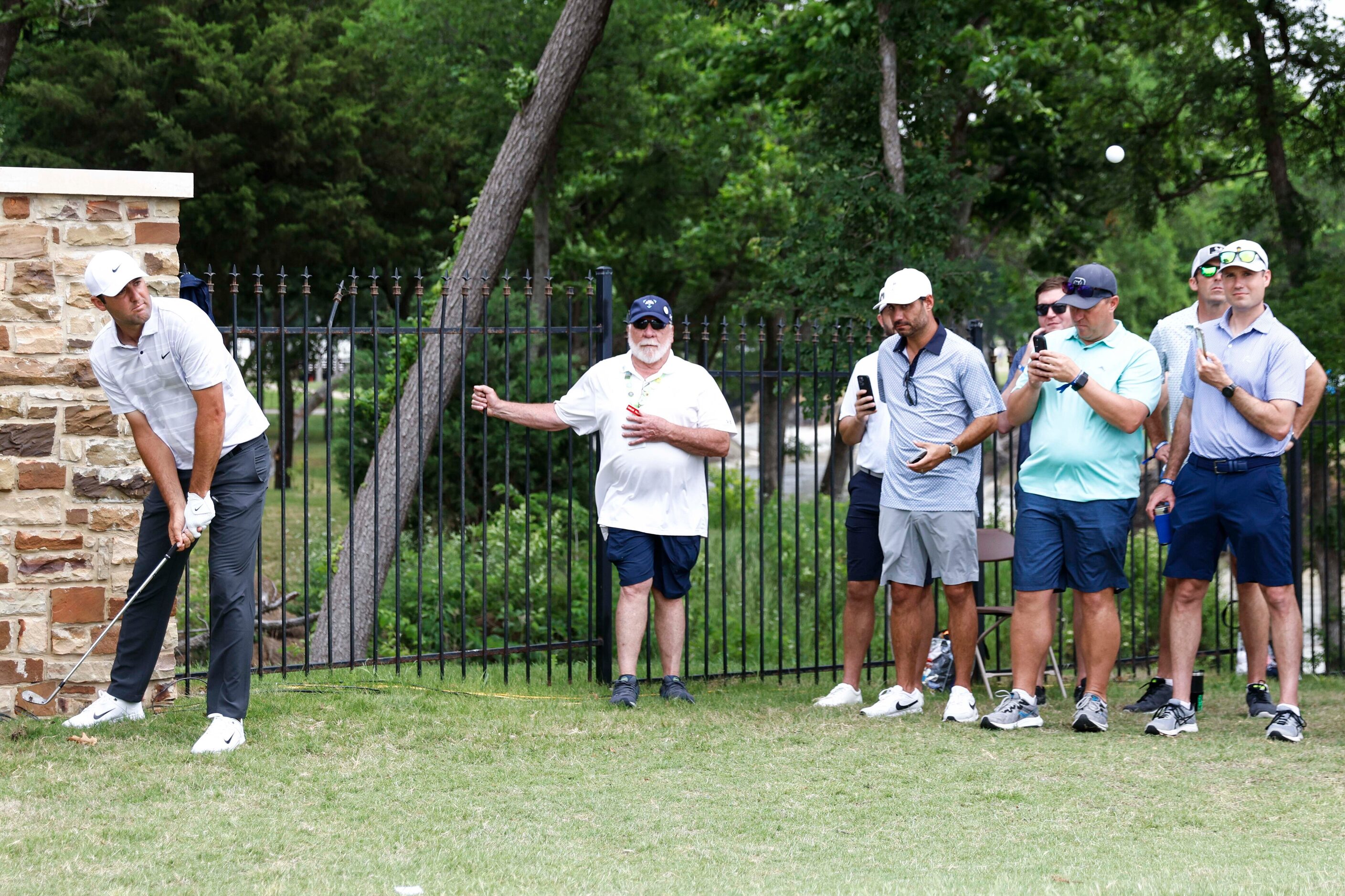 Scottie Scheffler of United States chips to the green of the eighth hole during the second...