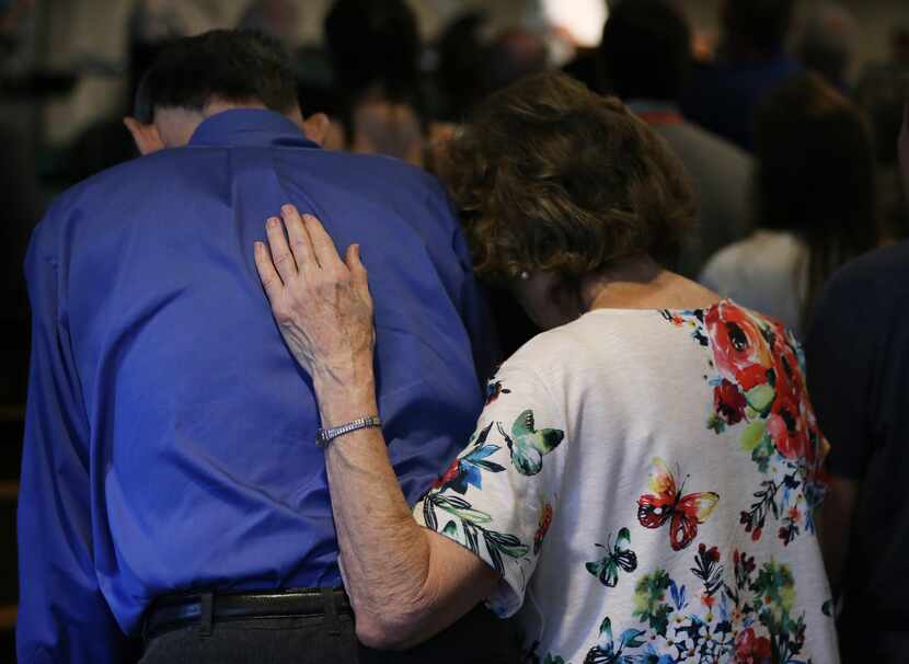 Worshippers embrace during worship service at Arcadia First Baptist Church in Santa Fe,...