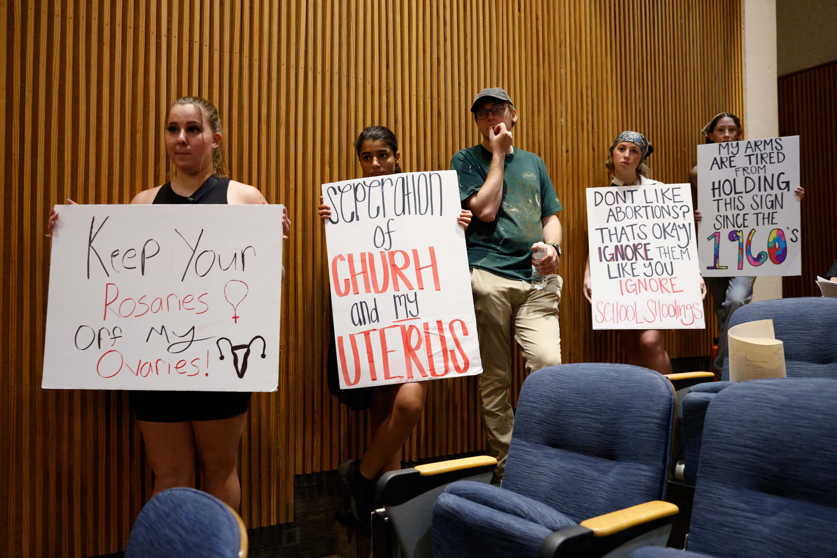 Abortion rights supporters hold signs during a Denton City Council meeting at Denton City...