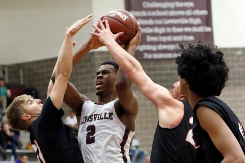 Lewisville's KJ Pruitt (2) puts up a shot against the aggressive defense of Coppell's Ben...