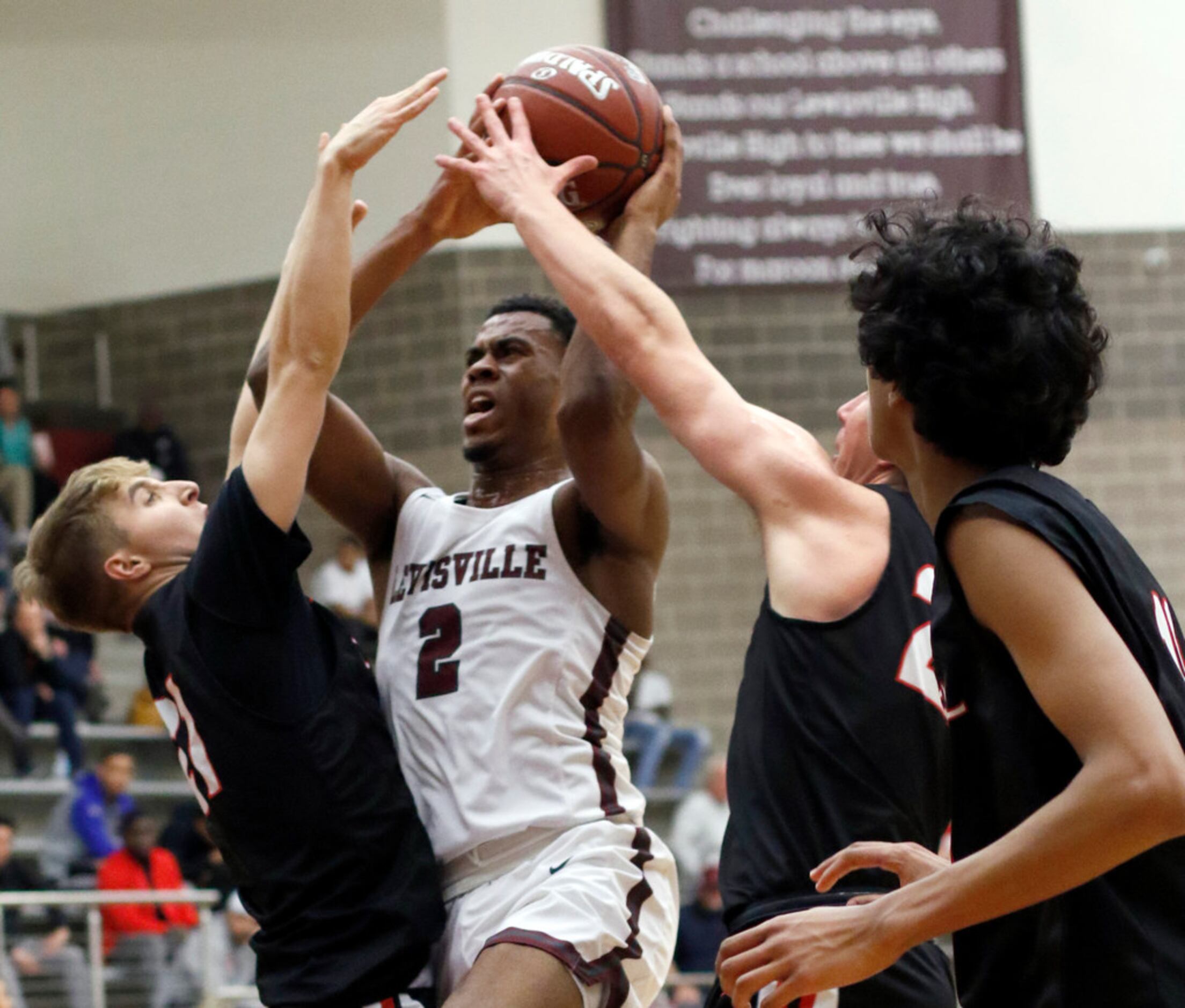 Lewisville's KJ Pruitt (2) puts up a shot against the aggressive defense of Coppell...