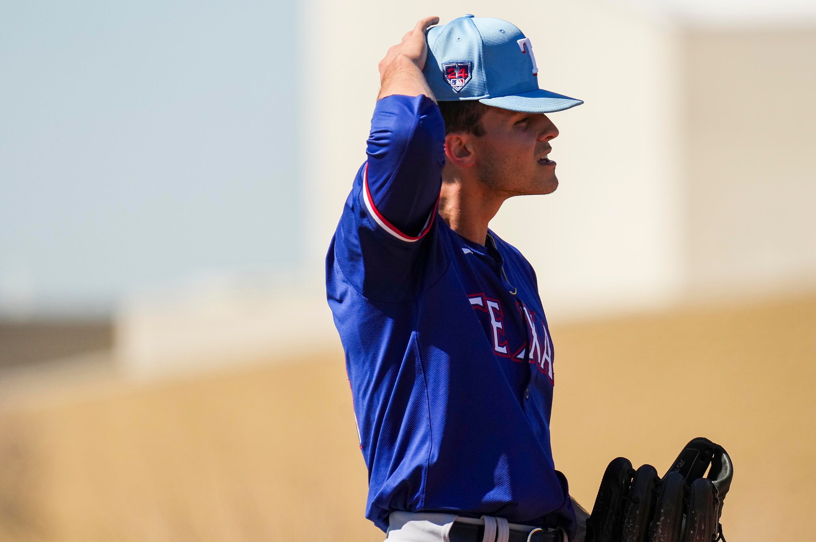 Texas Rangers pitcher Jack Leiter adjusts his cap while throwing live batting practice...