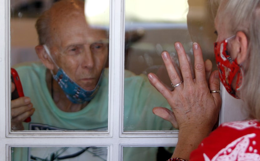 Richard “Captain” Playter and family friend Diane Cannon touch hands on either side of a...