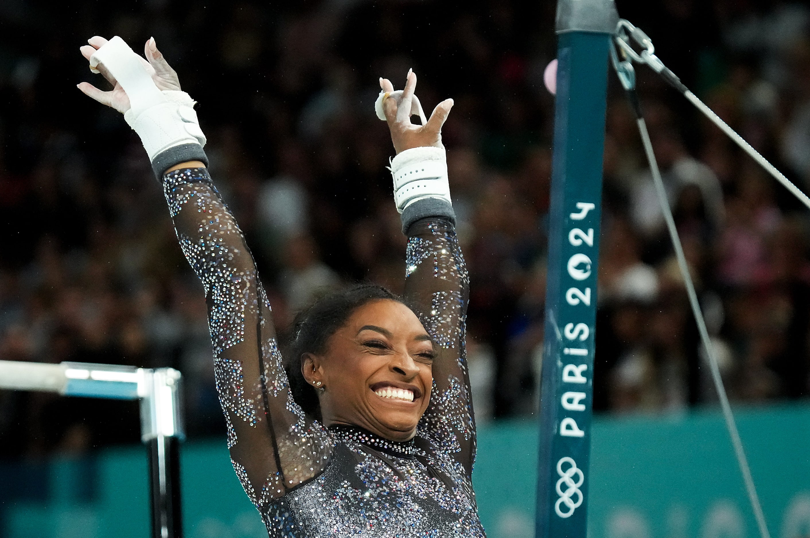 Simone Biles of the United States reacts after routine on the uneven bars during women’s...