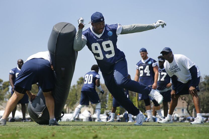 Dallas Cowboys defensive end Ryan Russell (99) hits a blocking dummy during a morning walk...