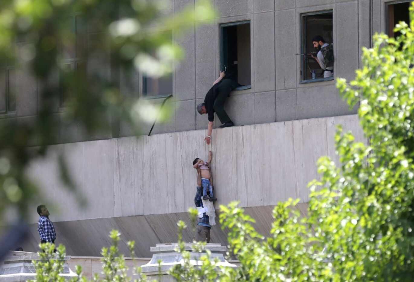Iranian police evacuate a child from the parliament building in Tehran on June 7, 2017....