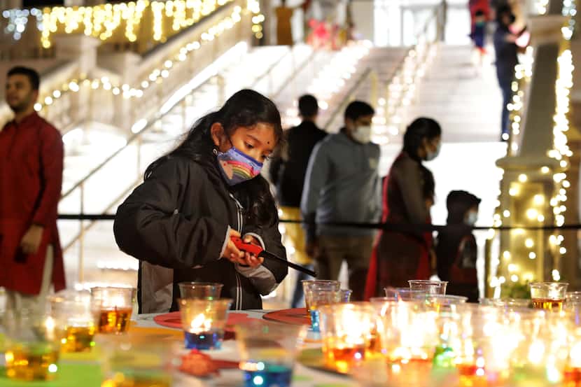 6-year-old Roshni Ranganathan lights a candle during the Diwali “Festival of Lights” event...