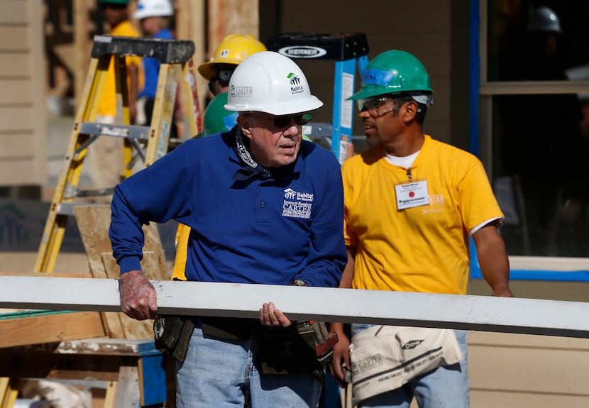 Former President Jimmy Carter helps cut wood for home construction at a Habitat for Humanity...