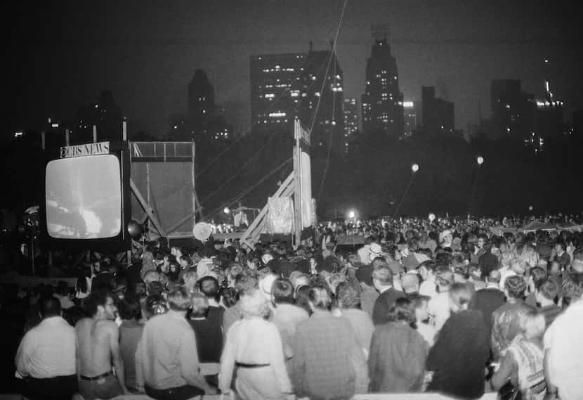  A crowd watches giant television screens in New York's Central Park on July 20, 1969, as...