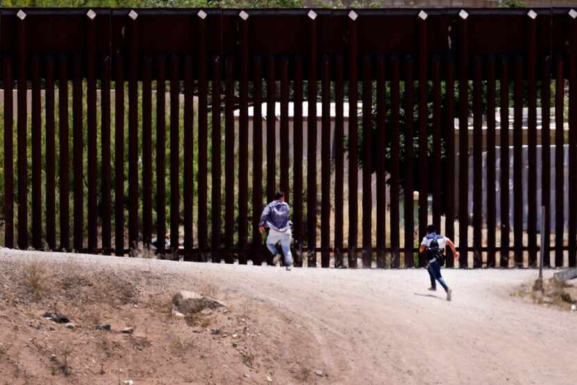 A pair of migrant children race back across the border as U.S. Customs and Border Protection...