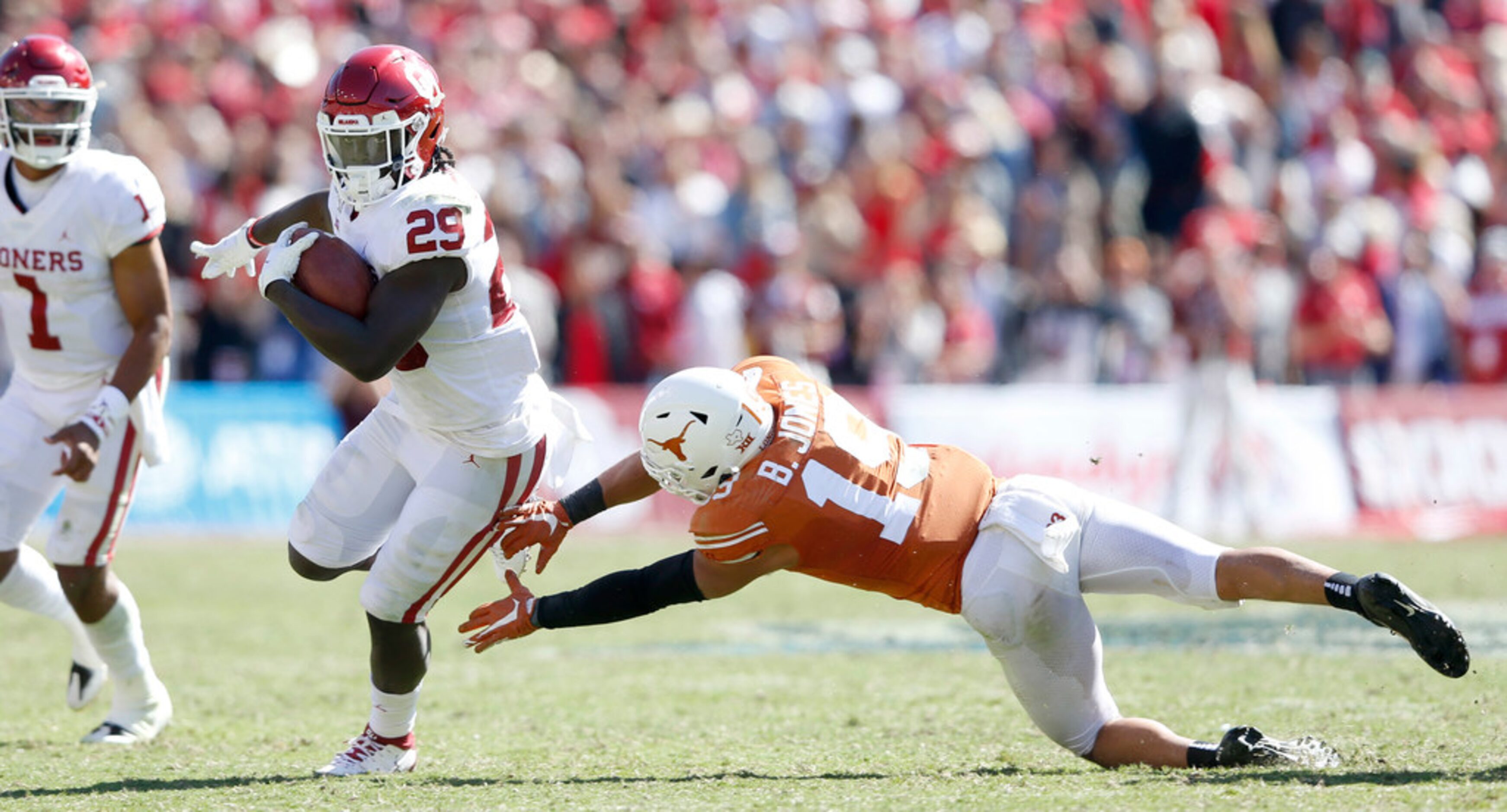 Oklahoma Sooners running back Rhamondre Stevenson (29) breaks a tackle attempt from Texas...