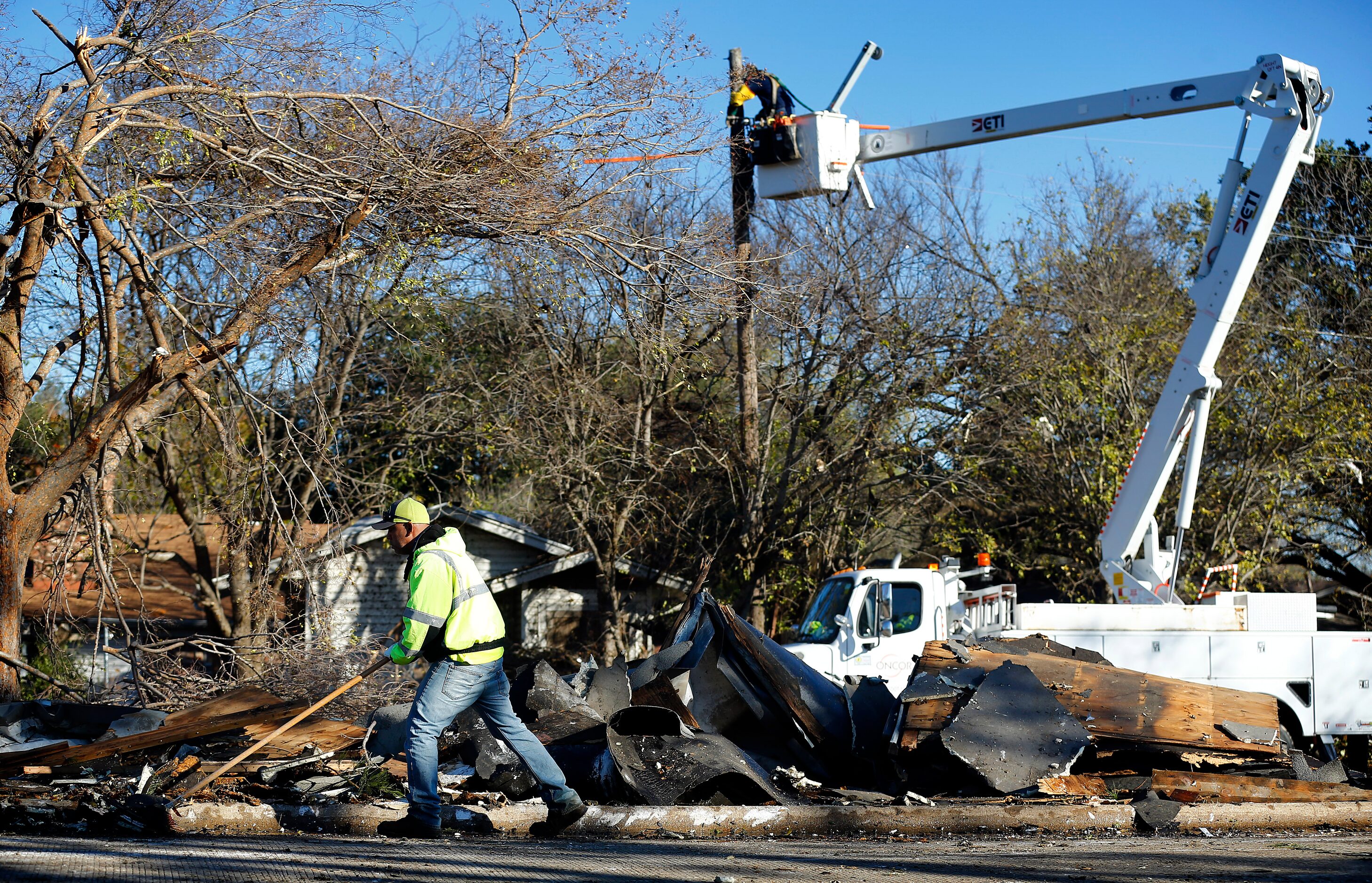 A City of Arlington street crewman cleans up debris from The Mirage Apartments complex along...