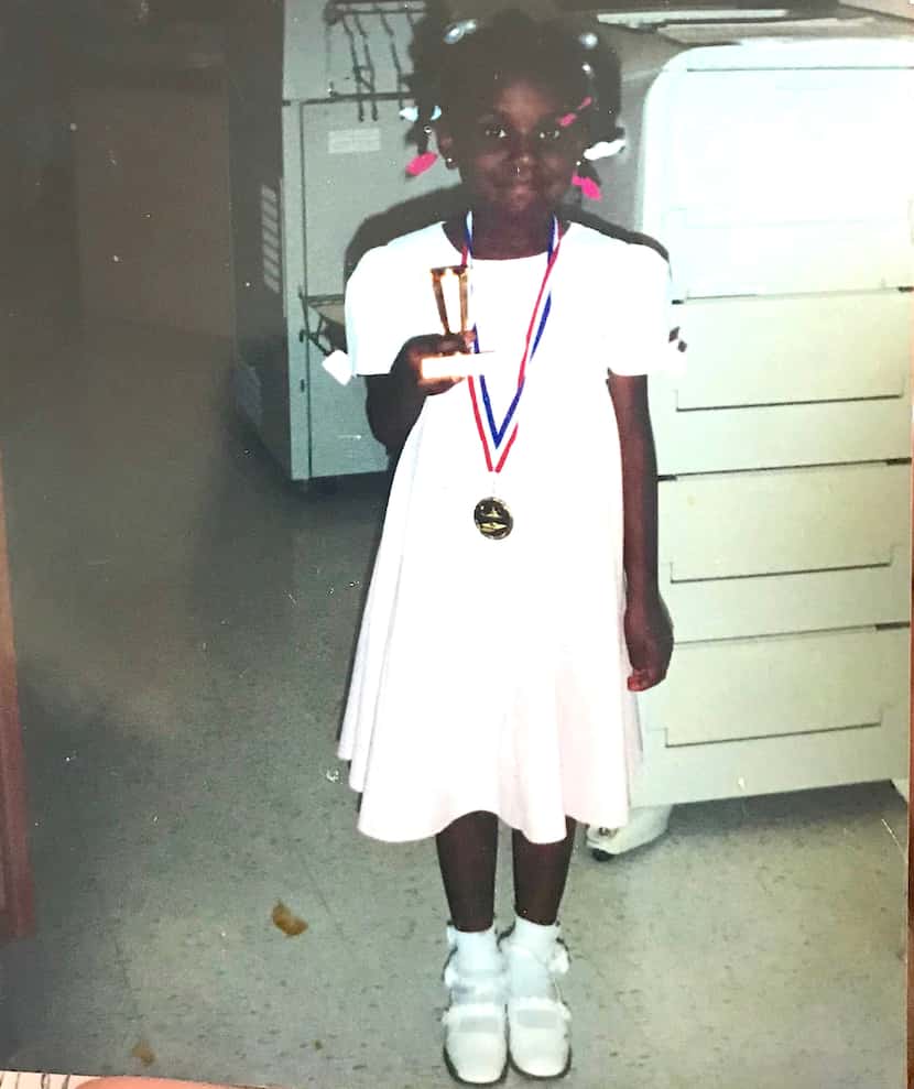 Kendra Allen, at about 6 years old, holding a trophy for placing first in a speech contest...
