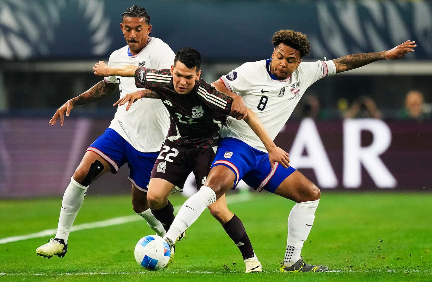 Mexico forward Hirving Lozano (22) is defended by United States midfielder Weston Mckennie...