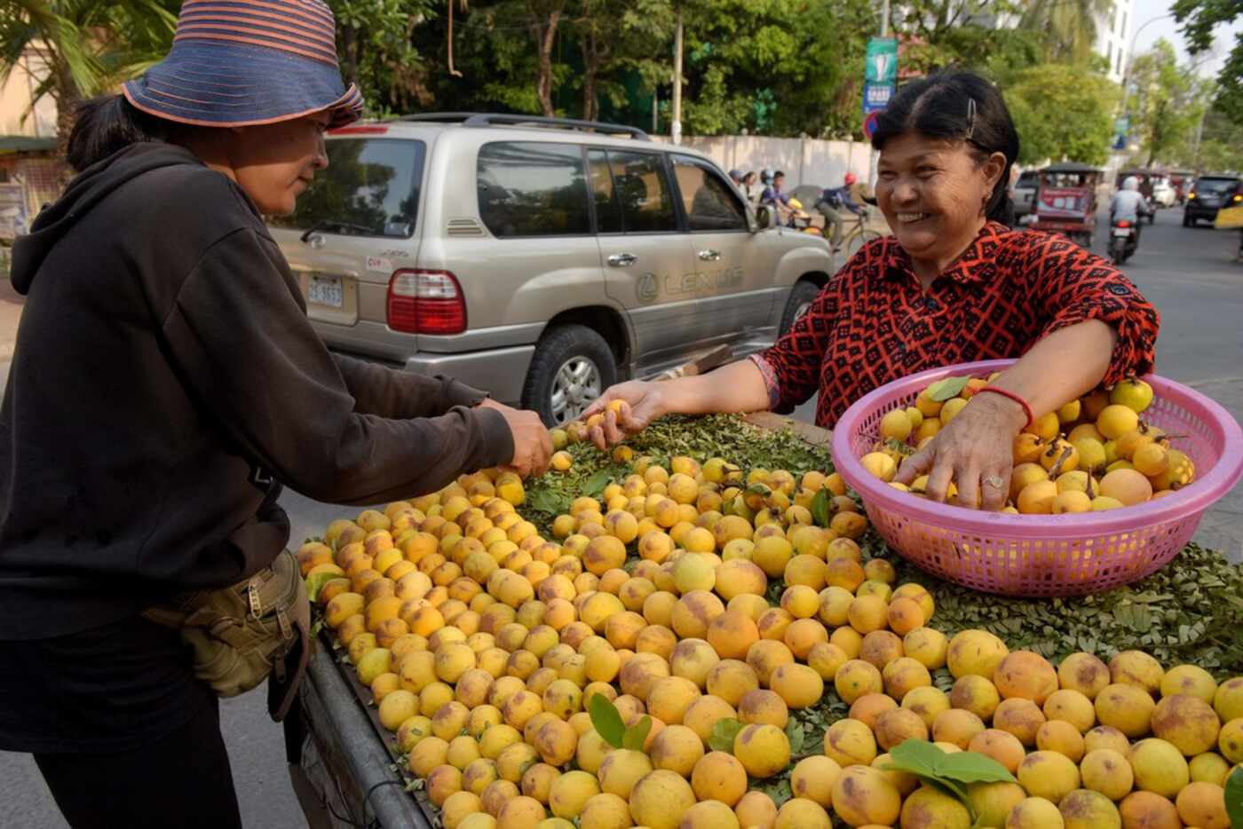 Cambodian vendors prepare willughbeia for sale along a street in Phnom Penh on March 23, 2018.