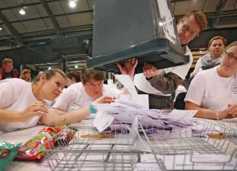 
Election workers peered into a ballot box as it was emptied Thursday in Aberdeen, Scotland....