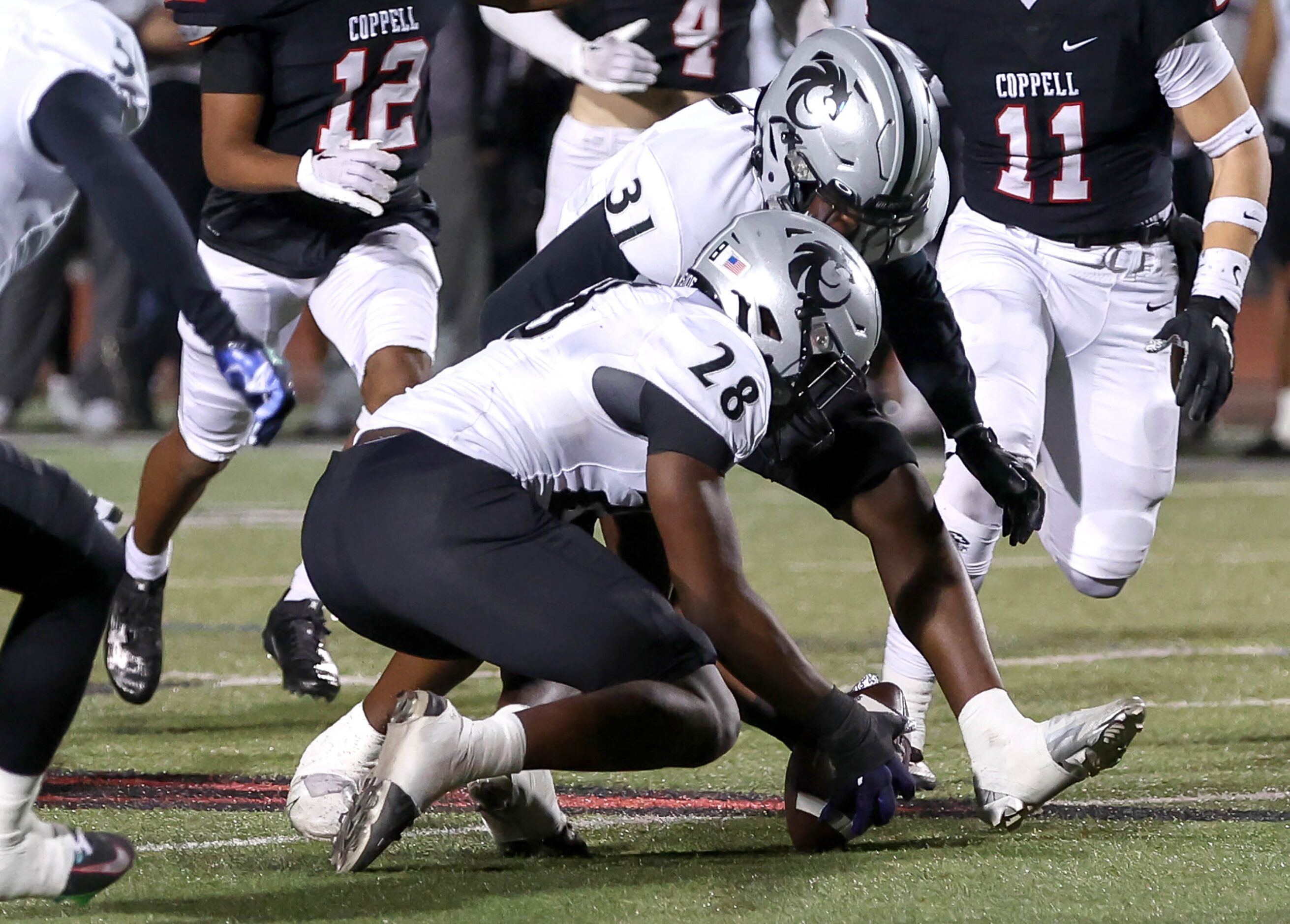 Denton Guyer's Hope Bebe (28) comes up with a recovery on an onside kick against Coppell...