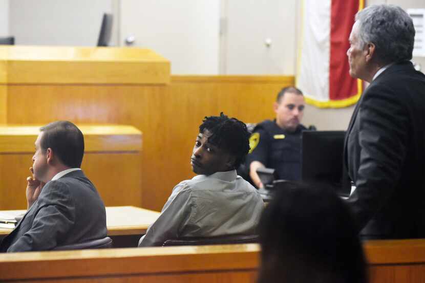 Desmond Jones, center, sits between his defense team attorney Jeff Lehman, left, and...