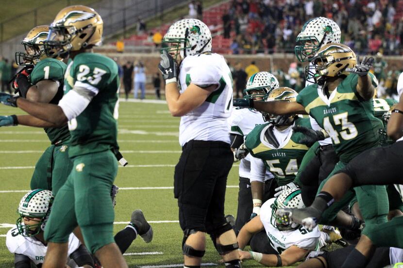 Southlake High quarterback Kenny Hill (far left) lies on the ground with the ball, as DeSoto...