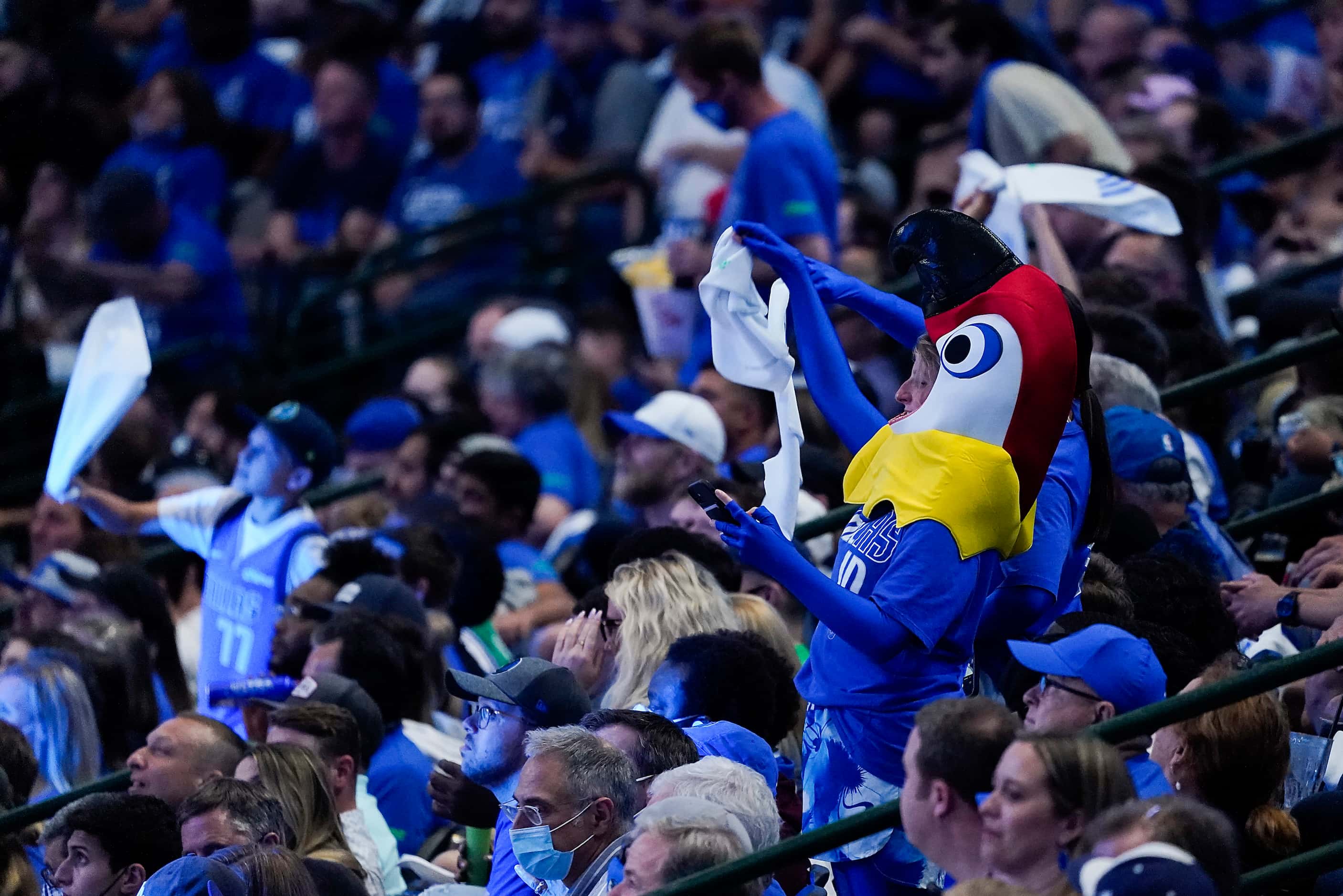 Dallas Mavericks fans dance during a timeout in the second quarter of an NBA playoff...