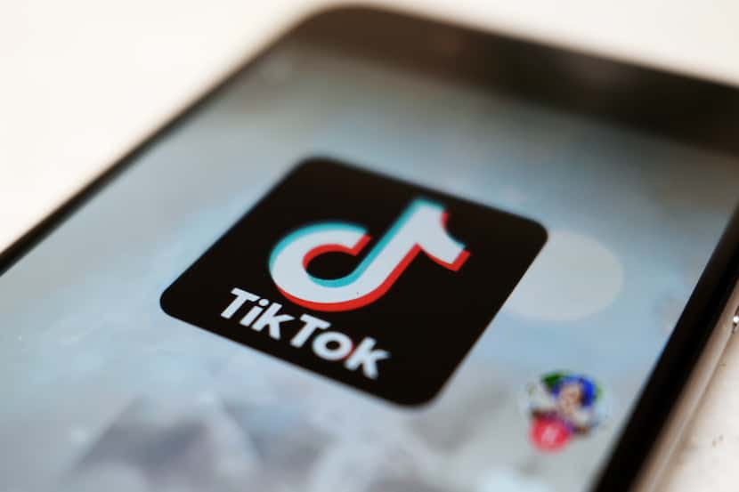 The TikTok logo is displayed on a smartphone screen.
