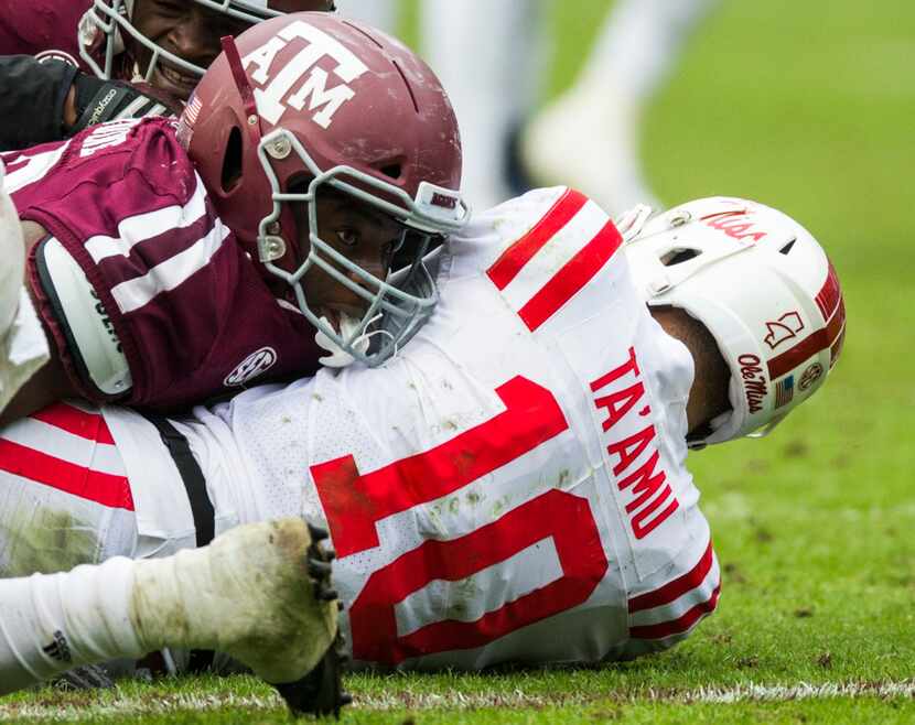 Texas A&M Aggies defensive lineman Justin Madubuike (52) lands on top of Ole Miss Landsharks...