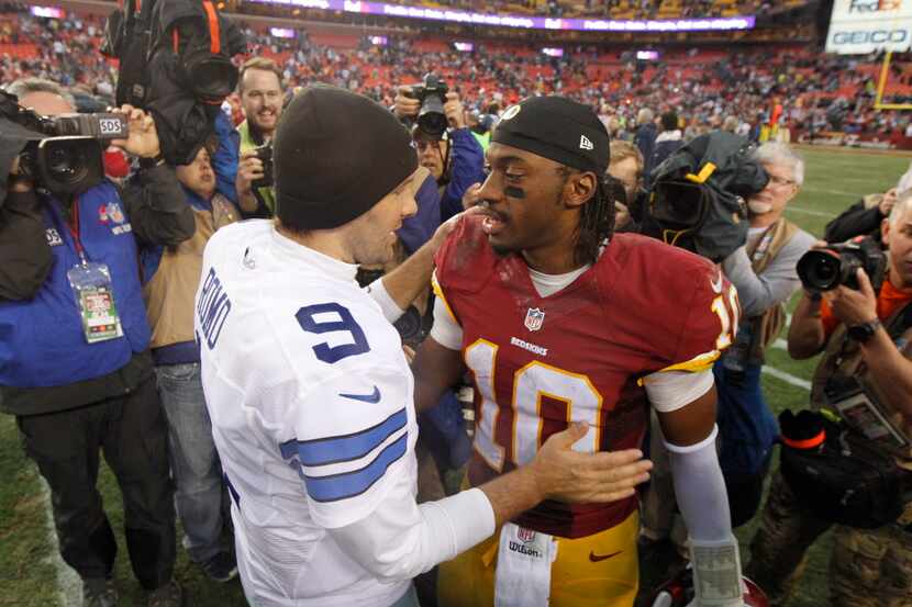 Dallas Cowboys quarterback Tony Romo (9) greets Washington Redskins quarterback Robert...