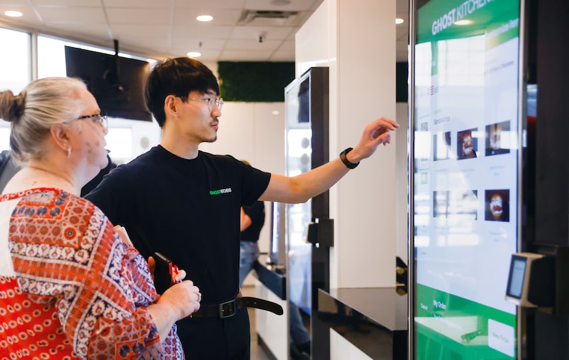 Ghost Kitchens manager Peter Choi (right) explains the process of ordering at the restaurant...