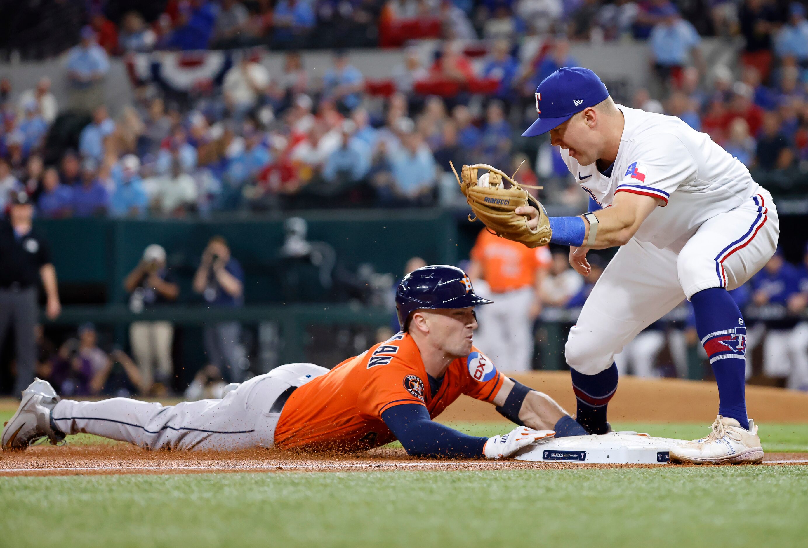 Houston Astros Alex Bregman (2) slides safely into third base ahead of the tag by Texas...