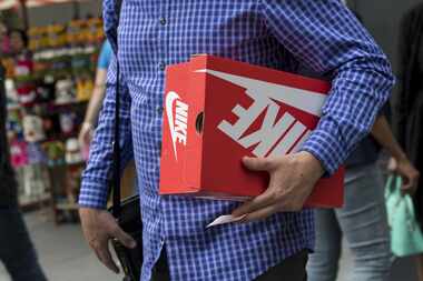 A shopper carries a Nike shoe box in San Francisco, Calif. 