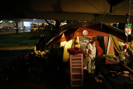  Rochelle Aslin, a Tent City resident of about three months, restocks the makeshift...