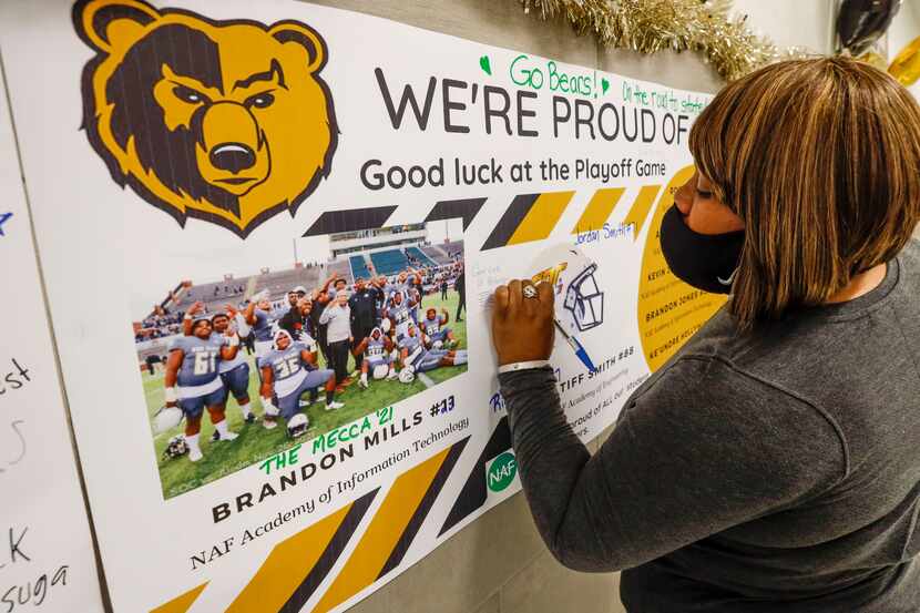 Staci Holloway, a Special Education teacher at South Oak Cliff High School, signs a poster...