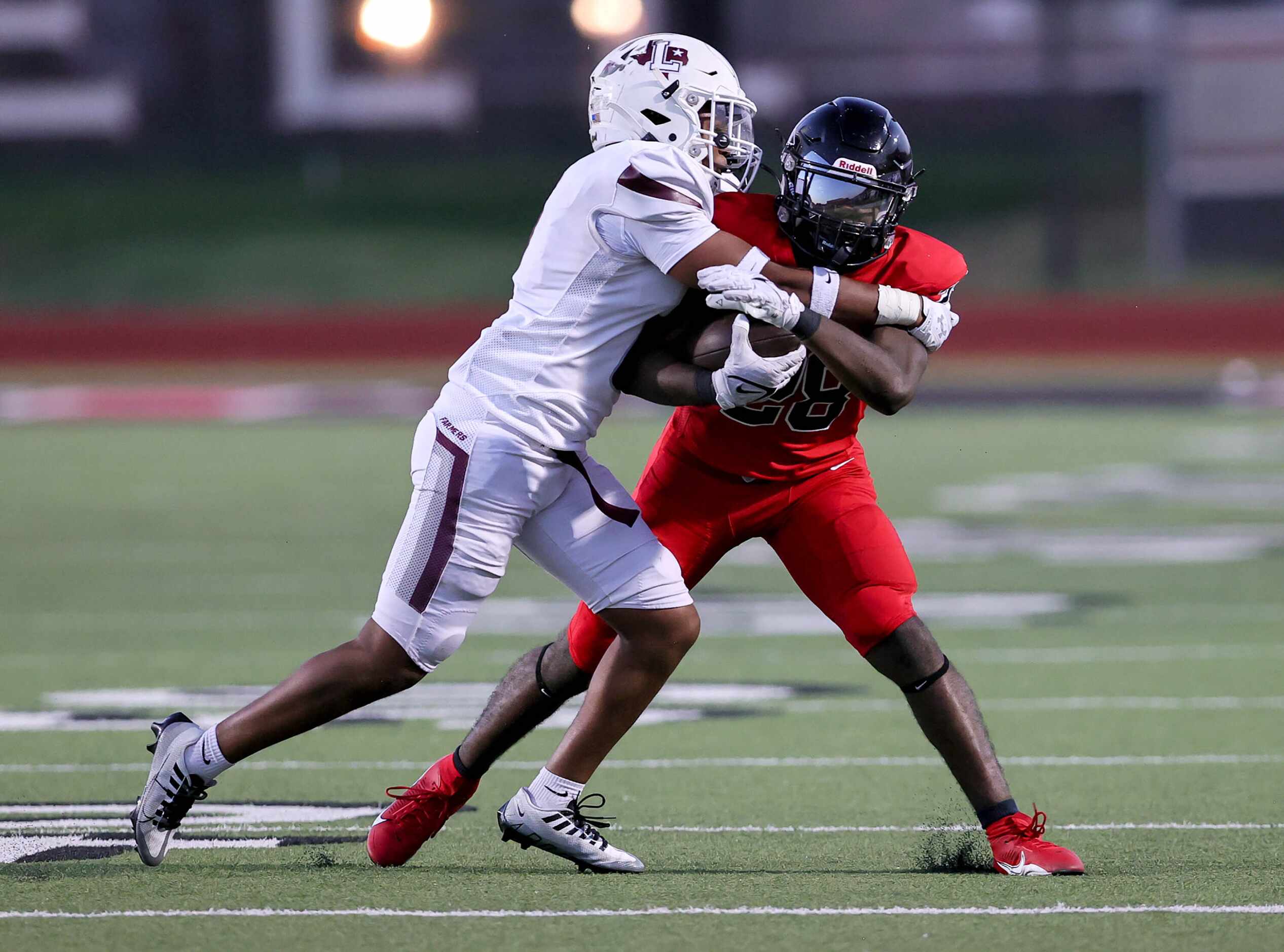 Coppell running back Xavier Mosely (28) is stopped by Lewisville defensive back Ke'Shawn...