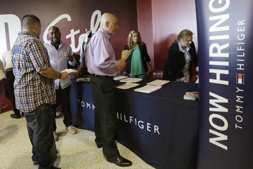 FILE - In this June 10, 2015, file photo, job seekers attend a job fair in Sunrise, Fla. On...