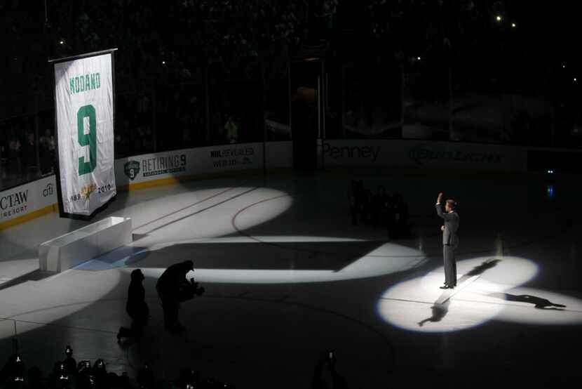 Former Dallas Stars and NHL player  Mike Modano hugs Dirk Nowitzki during his  jersey...