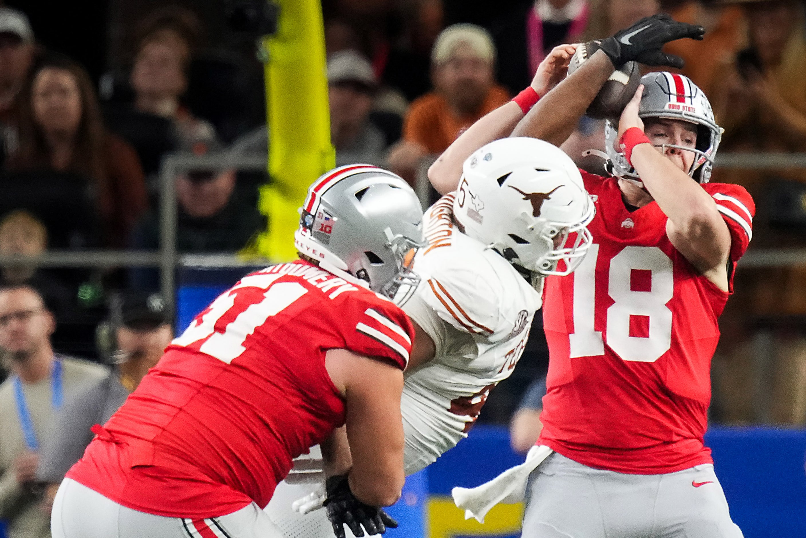 Ohio State quarterback Will Howard (18) is hit by Texas defensive lineman Vernon Broughton...