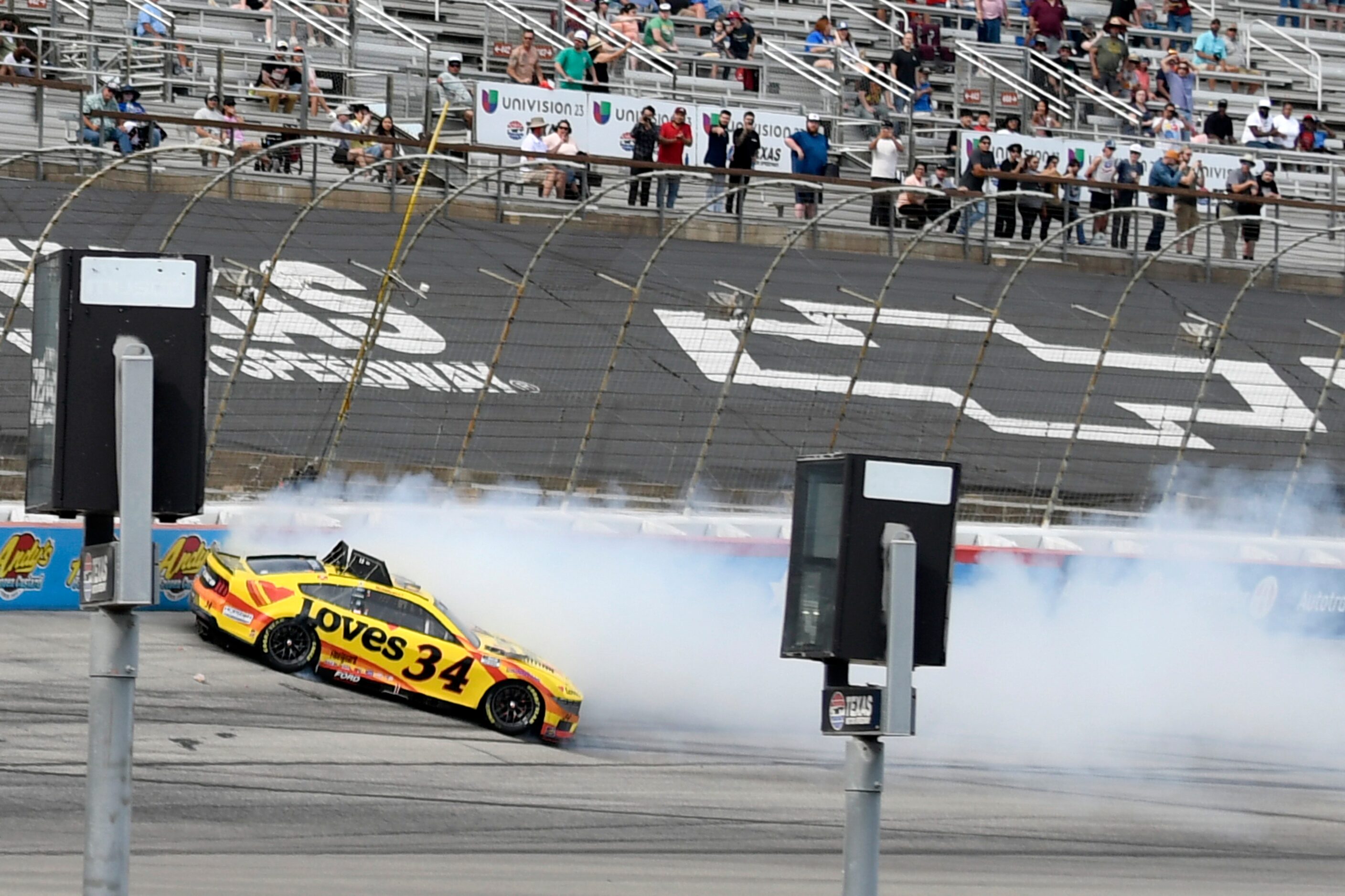 Fans look on as Michael McDowell (34) crashes in Turn 4 during a NASCAR Cup Series auto race...