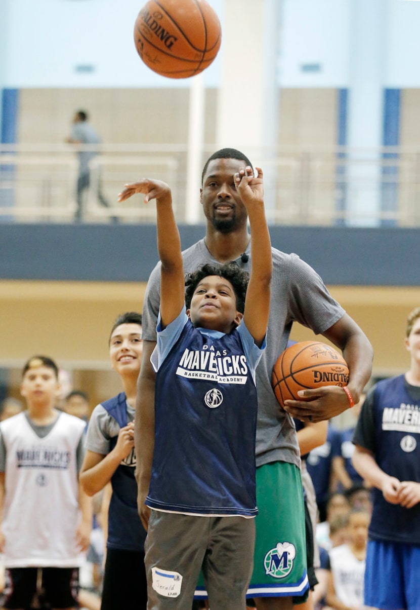 Jerald Harper competes against Dallas Mavericks forward Harrison Barnes in a game of...