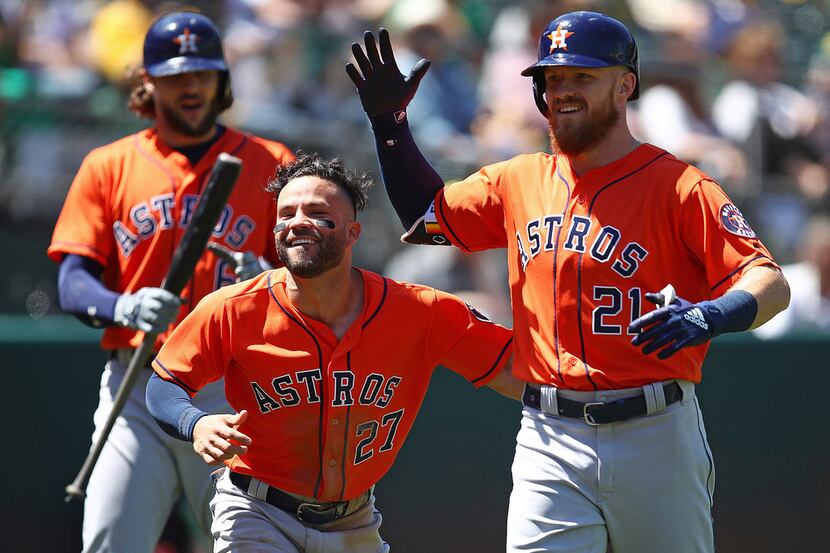 Houston Astros' Derek Fisher, right, celebrates with Jose Altuve (27) after hitting a home...