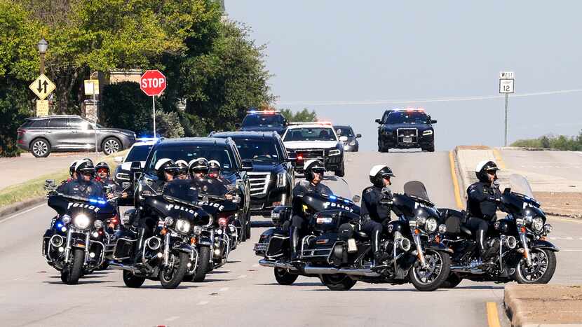 Motorcycle police officers lead a processional along West Northwest Highway before a funeral...