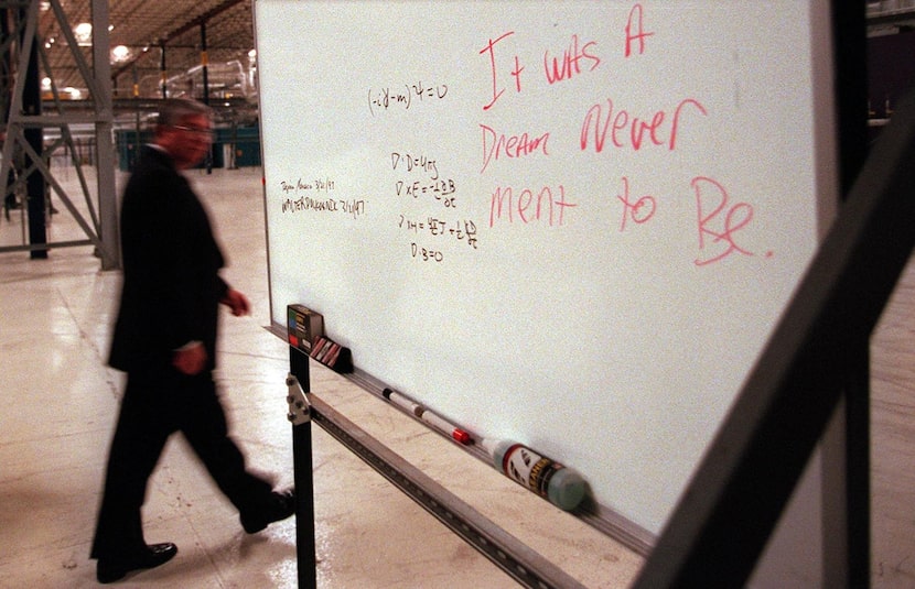 Texas General Land Office Project Director  Mabry J. Brock walks past a board expressing...