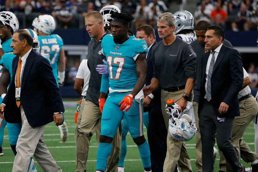 Team staff assist Miami Dolphins' Allen Hurns (17) off the field after he suffered an...