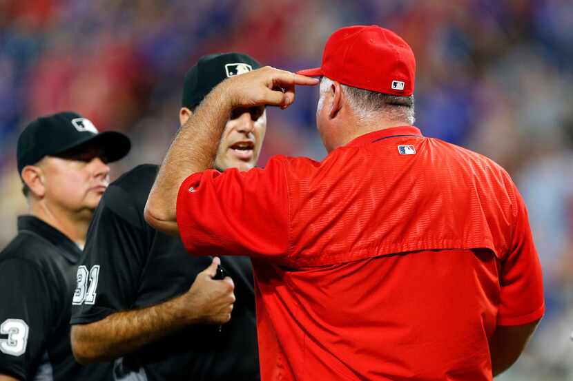 Los Angeles Angels manager Mike Scioscia (14) had a few words with umpire Pat Hoberg (31)...