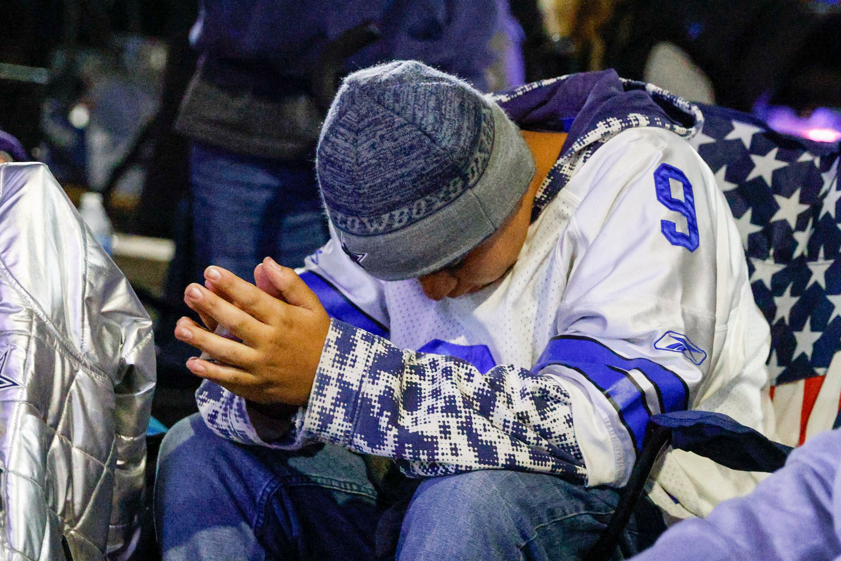 Korbin Sergio, 13, says a prayer during the final minutes of an NFL wild-card playoff game...